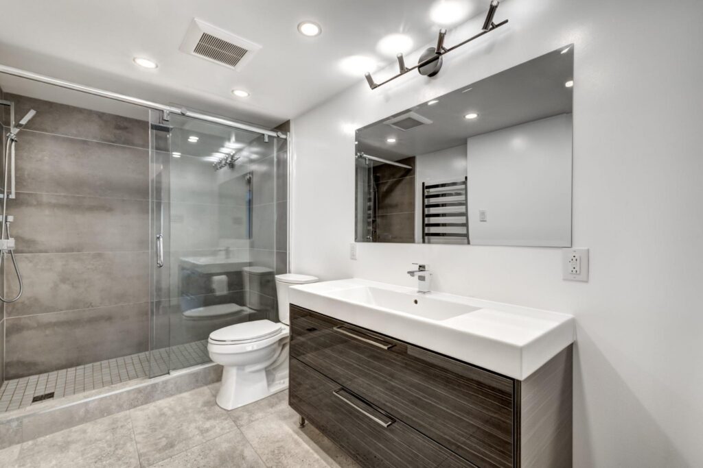 Contemporary bathroom remodel with floating vanity, single sink, glass walk-in shower, and gray tile finishes in Greater Missoula.